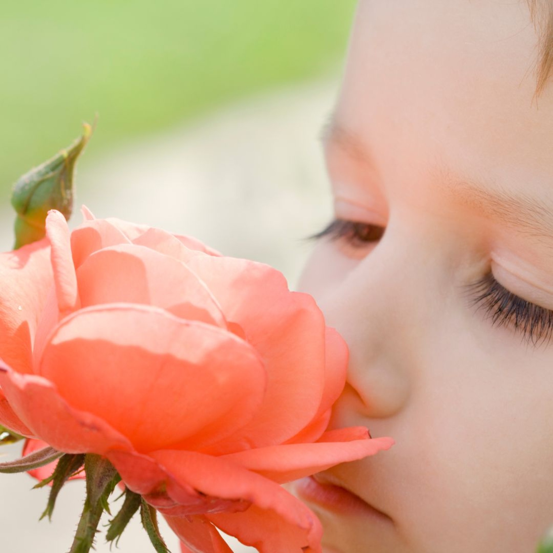 Child smelling rose.